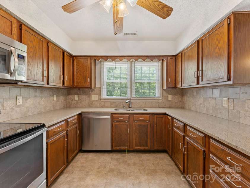 4601 Bournewood Lane, Charlotte, NC 28226.  MLS# CAR4278475, YatesRealty ID 25454. The kitchen offers a lot of prep space on its granite countertops.