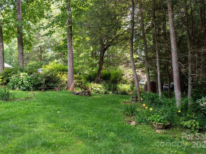 29 Honey Hollow Lane, Fairview, NC 28730.  MLS# CAR4270487, YatesRealty ID 25480. Flowering landscape surrounds fire pit
