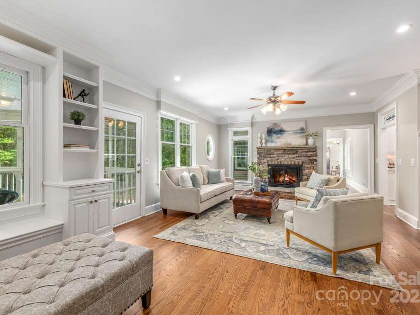 3201 Oak Brook Drive, Waxhaw, NC 28173.  MLS# CAR4247605, YatesRealty ID 25490. Cozy Den outside of the kitchen features a lovely stone fireplace, site-finished hardwood flooring and has custom built-ins