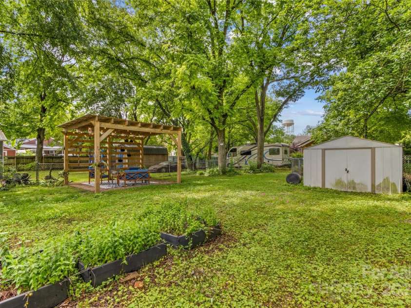 119 Wiley Avenue, Salisbury, NC 28144.  MLS# CAR4250756, YatesRealty ID 25522. Raised beds in backyard with pergola and shed