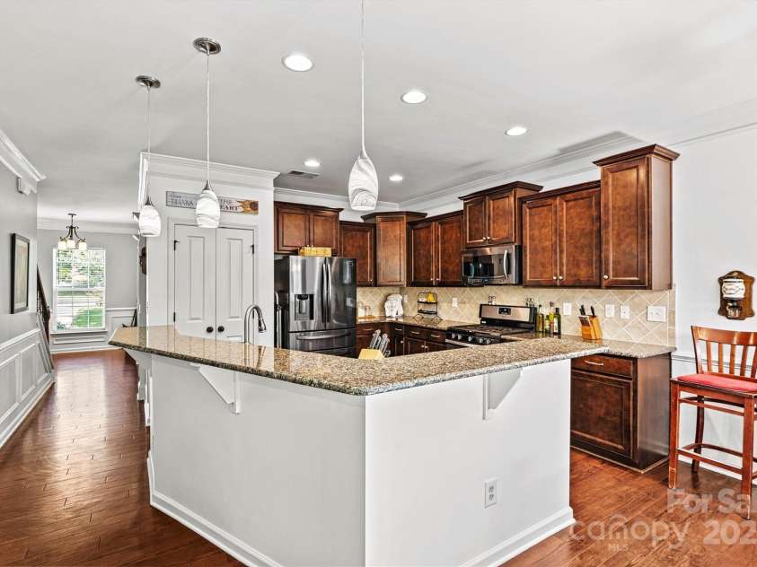 112 Heart Pine Lane, Statesville, NC 28677.  MLS# CAR4271076, YatesRealty ID 25527. Stunning kitchen featuring stainless steel appliances, rich wood cabinets and floors, and granite counters.