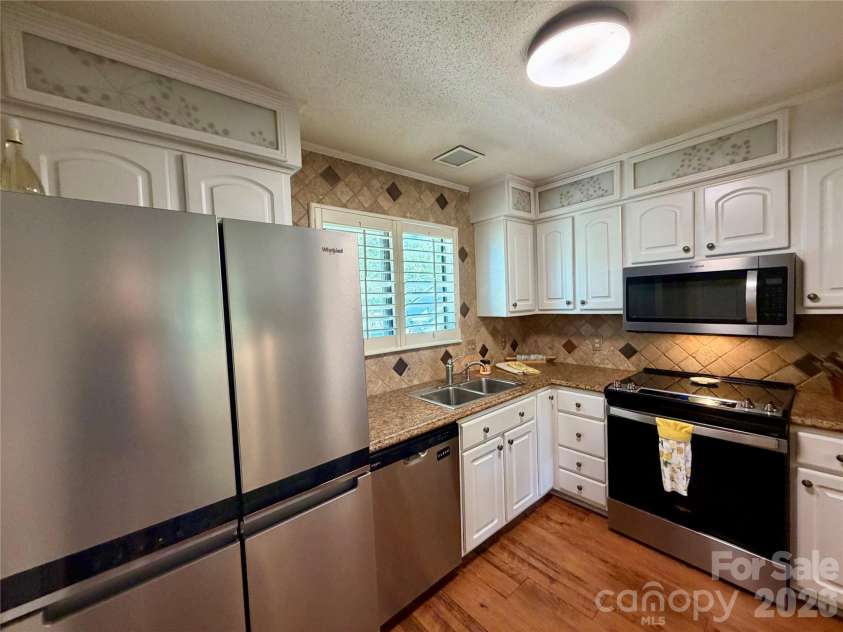 3100 Heathstead Place, Charlotte, NC 28210.  MLS# CAR4382237, YatesRealty ID 25547. Another view of the kitchen.  Lots of cabinet storage.  Tile backsplash is sleek and neutral.  Stainless appliances make cooking and entertaining a breeze.