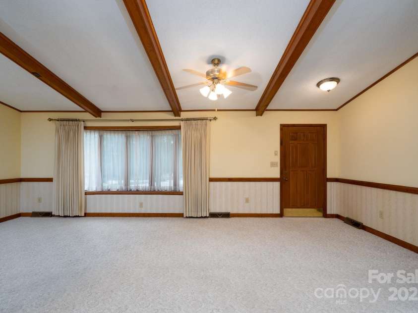 614 Azalea Lane, China Grove, NC 28023.  MLS# CAR4280599, YatesRealty ID 25550. View from living room looking at dining room and multiple bay windows. Nice wood beam accents in ceiling.