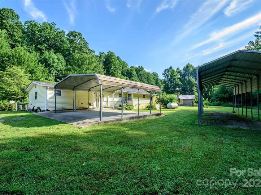 4720 Brevard Road, Horse Shoe, NC 28742.  MLS# CAR4278026, YatesRealty ID 25552. Back of home with covered parking and RV covered parking