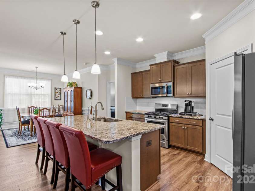 117 Cup Chase Drive, Mooresville, NC 28115.  MLS# CAR4279101, YatesRealty ID 25558. Kitchen maple cabinets, crown molding, pendant lighting, s/steel gas range, microwave and dishwasher