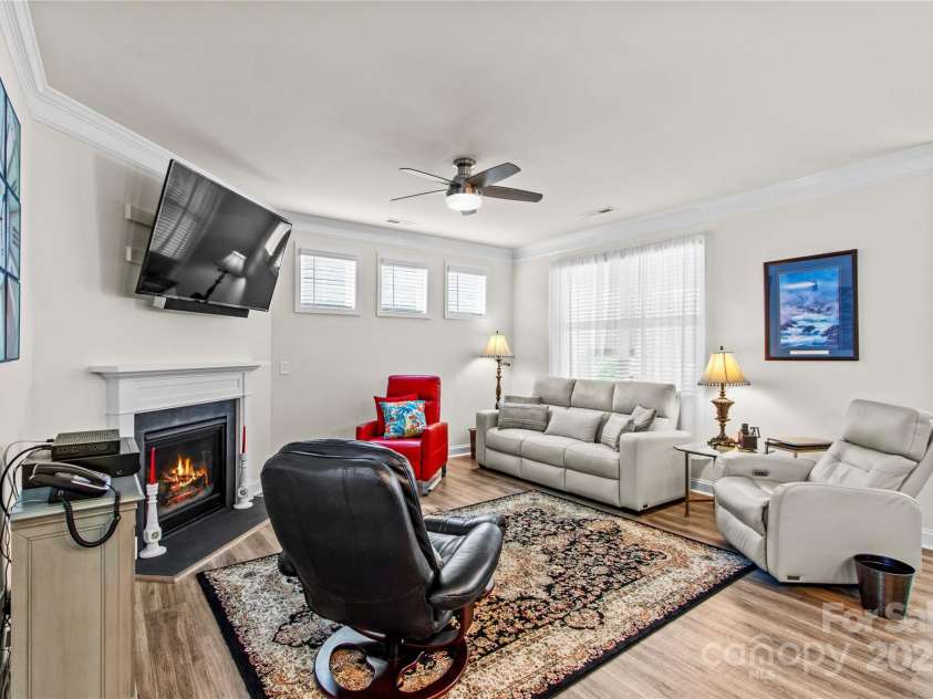 117 Cup Chase Drive, Mooresville, NC 28115.  MLS# CAR4279101, YatesRealty ID 25558. Living room with ceiling fan, TV mount over gas fireplace, crown molding, LVP flooring