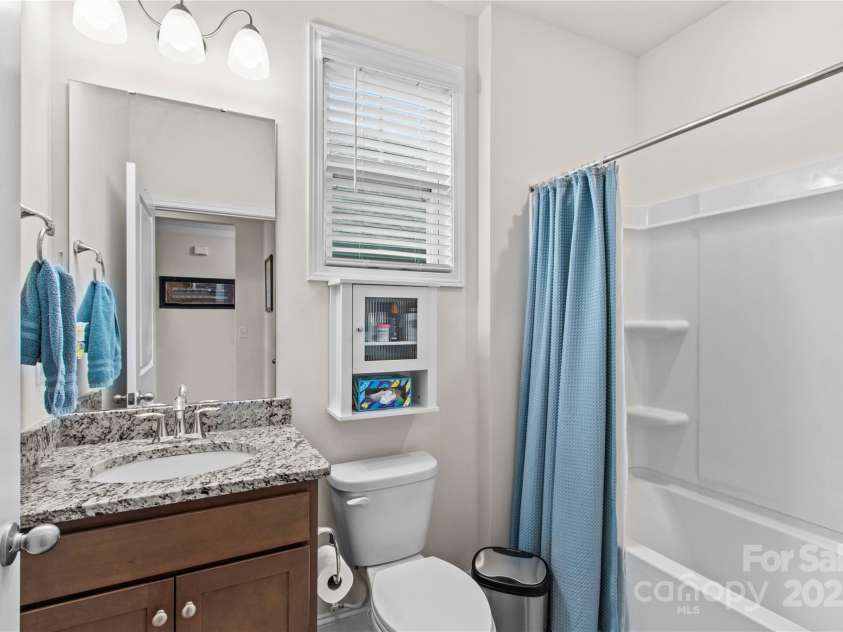 117 Cup Chase Drive, Mooresville, NC 28115.  MLS# CAR4279101, YatesRealty ID 25558. Main level secondary bath with granite countertop, toiletry cabinet over commode