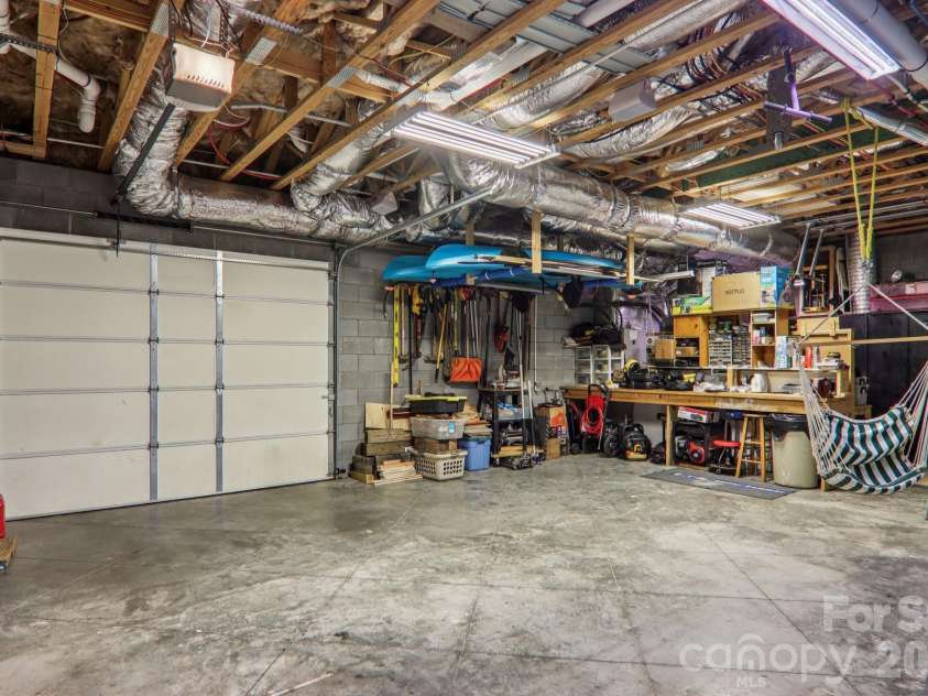 6 Wagon Trace, Flat Rock, NC 28731.  MLS# CAR4374692, YatesRealty ID 25583. Basement workshop with garage door