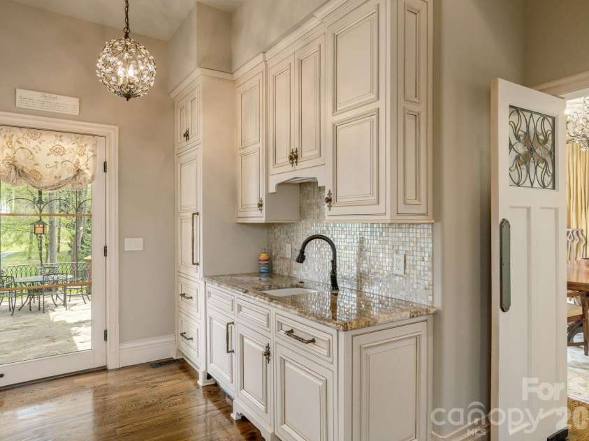 8 Fairway Place, Asheville, NC 28803.  MLS# CAR4245541, YatesRealty ID 2564. Adjacent to the Formal Dining is a refined butler’s pantry, highlighted by backlit English Art Nouveau stained-glass antique doors. 