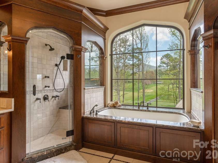 8 Fairway Place, Asheville, NC 28803.  MLS# CAR4245541, YatesRealty ID 2564. Luxurious primary en-suite featuring a walk-in shower and spa-like amenities.