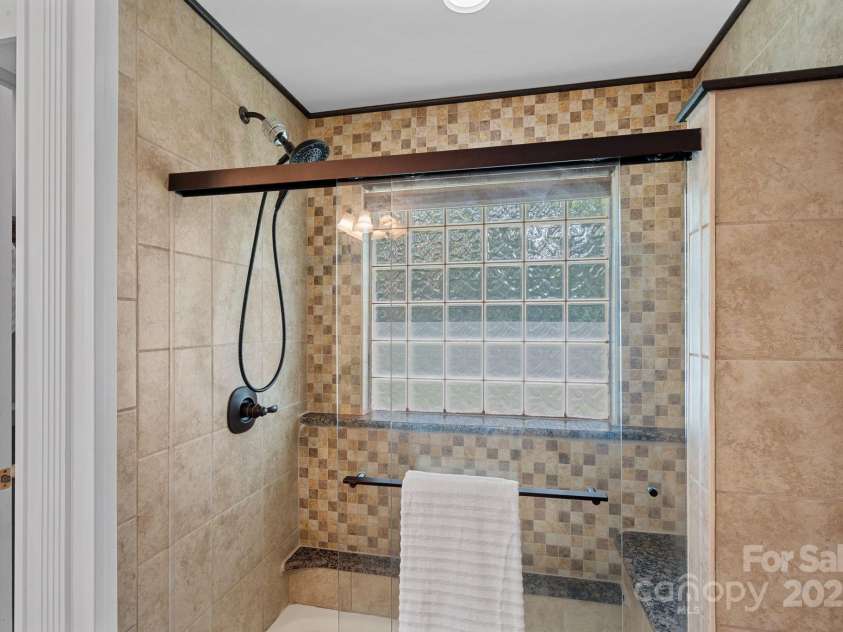 7478 Pine Ridge Drive, Denver, NC 28037.  MLS# CAR4272908, YatesRealty ID 25697. Primary bathroom features a tiled shower with a built-in bench seat for added convenience.