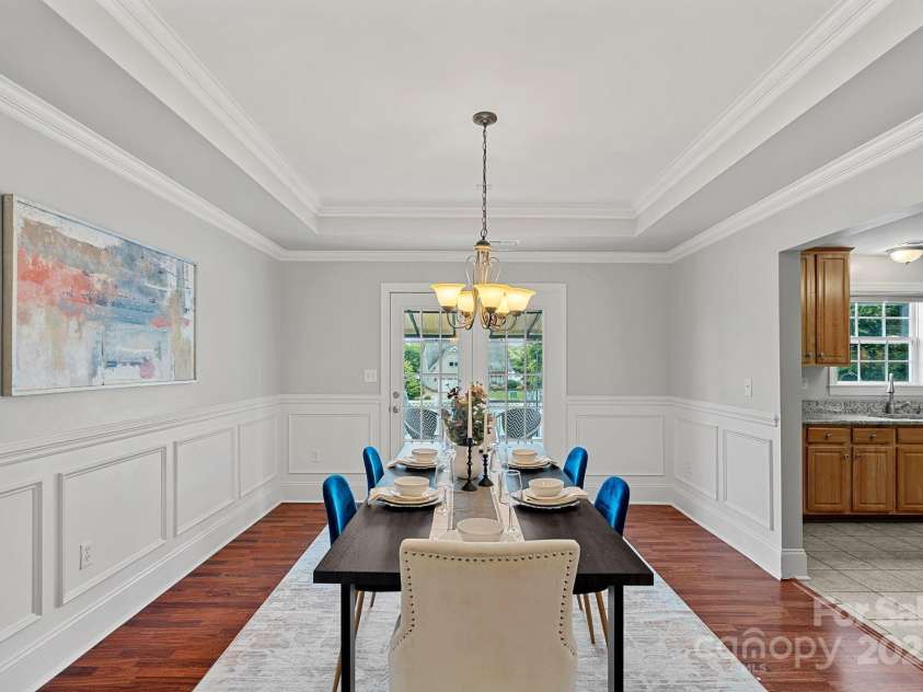 7478 Pine Ridge Drive, Denver, NC 28037.  MLS# CAR4272908, YatesRealty ID 25697. The dining room featuring tray ceiling, crown molding, chair rail, and picture molding details.