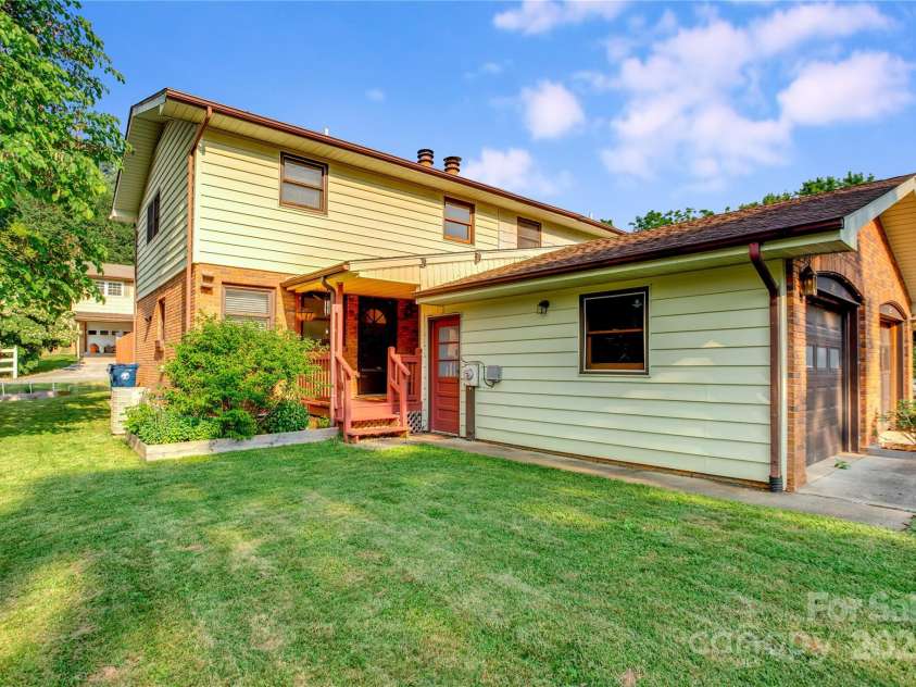 26 Pebblebrook Street, Clyde, NC 28721.  MLS# CAR4268095, YatesRealty ID 25732. Sunny front yard with detached garage.