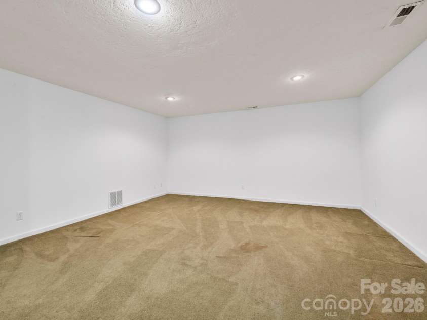 37 Leatherwood Drive, Candler, NC 28715.  MLS# CAR4376131, YatesRealty ID 25753. Lower-level Den area