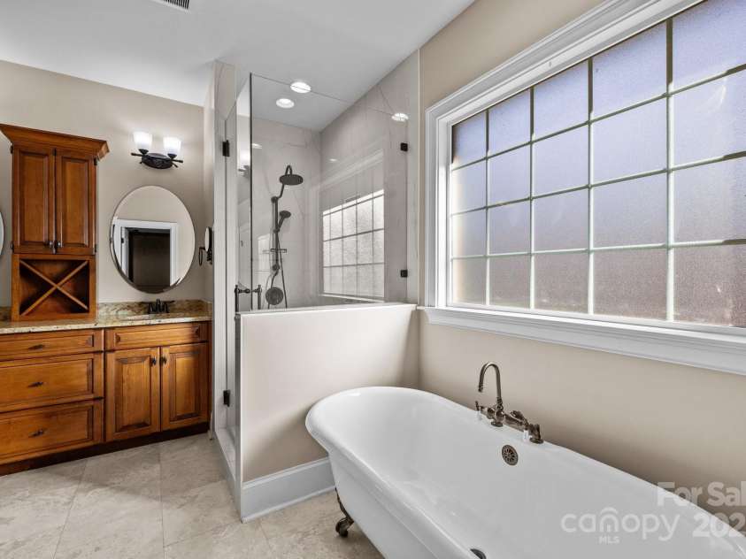 11280 Mcfalls Drive, Indian Land, SC 29707.  MLS# CAR4225880, YatesRealty ID 25762. Among the stand out features of the estate is the owners private and luxurious bath suite featuring a newly redesigned custom shower. Dual vanities, a free standing claw foot tub and travertine floors are additional 