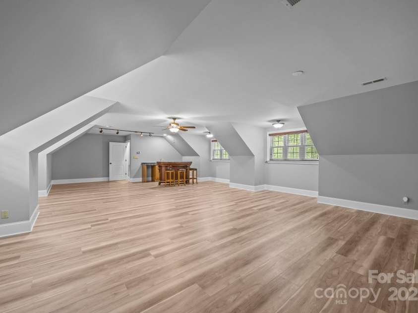11280 Mcfalls Drive, Indian Land, SC 29707.  MLS# CAR4225880, YatesRealty ID 25762. Before and after picture of 2nd level bonus room showing new floors and paint.