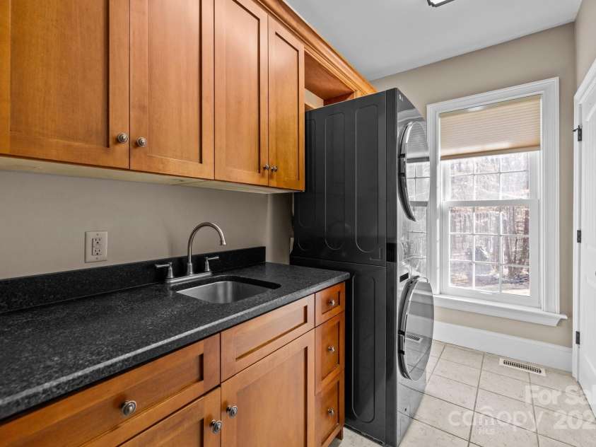 11280 Mcfalls Drive, Indian Land, SC 29707.  MLS# CAR4225880, YatesRealty ID 25762. Here is the centrally located yet tucked away laundry room with full custom cabinetry, hot and cold sink and daily Carolina sunshine.