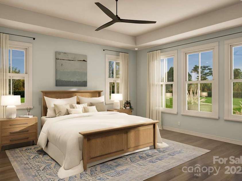 Lot 4 Country Estates Drive, Waxhaw, NC 28173.  MLS# CAR4278303, YatesRealty ID 25767. This spacious primary bedroom features a tray ceiling and expansive windows that flood the room with natural light and frame serene outdoor views.