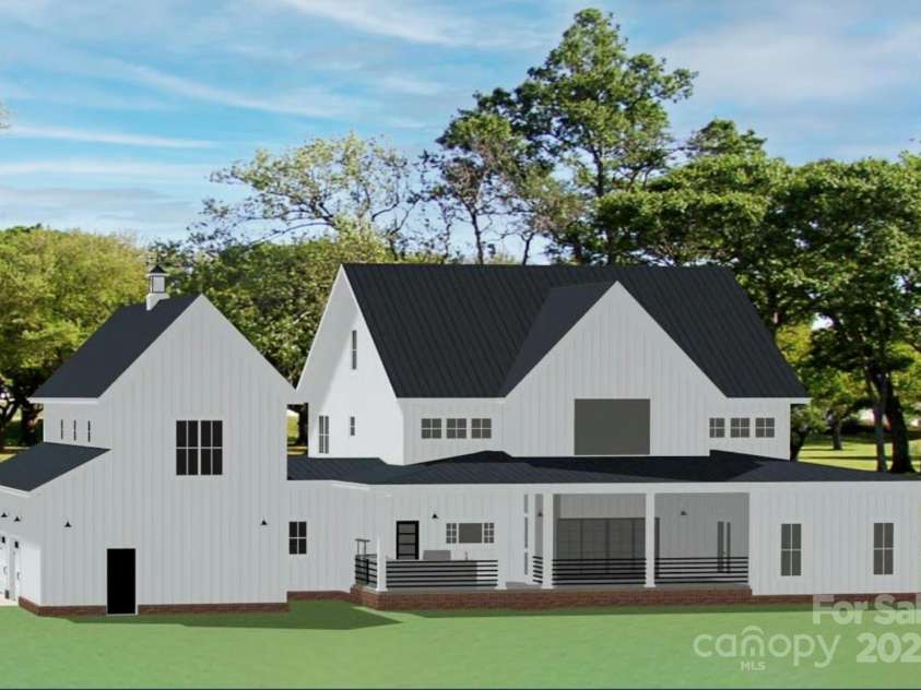 Lot 5 Country Estates Drive, Waxhaw, NC 28173.  MLS# CAR4278674, YatesRealty ID 25768. Rear view highlights its large covered porch, clean board-and-batten siding, a sleek black metal roof, and a three-car garage with a cupola-topped gable.
