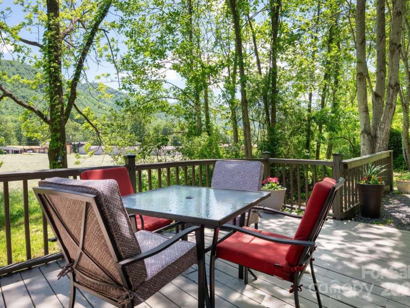 104 Riddle Cove Road, Maggie Valley, NC 28751.  MLS# CAR4257628, YatesRealty ID 25771. Creekside fire pit with Adirondack seating-perfect for guests or evening relaxation.
