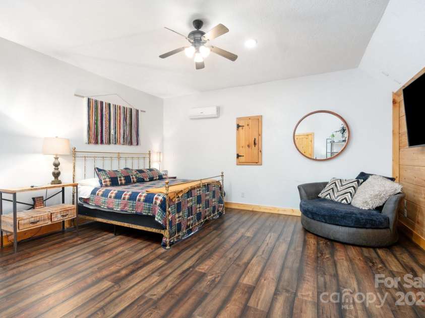 104 Riddle Cove Road, Maggie Valley, NC 28751.  MLS# CAR4257628, YatesRealty ID 25771. Spacious primary suite with mini-split, wood accents, and sitting area.