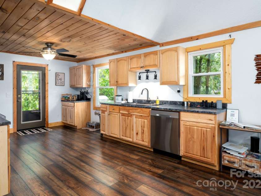 104 Riddle Cove Road, Maggie Valley, NC 28751.  MLS# CAR4257628, YatesRealty ID 25771. Well-equipped kitchen with stainless appliances, wood cabinetry, and direct access to the backyard.