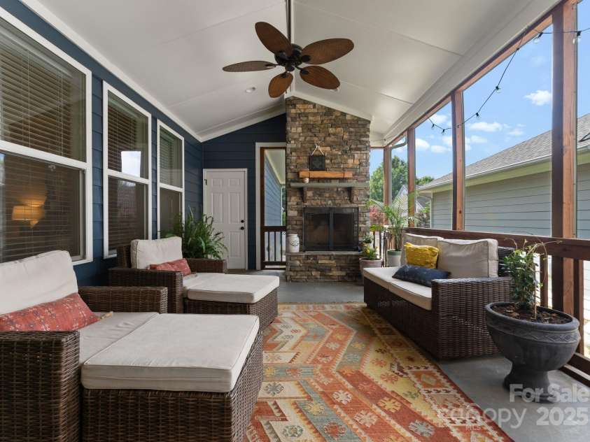 5137 Rialto Street, Belmont, NC 28012.  MLS# CAR4277416, YatesRealty ID 25831. Step through elegant French doors into the spacious screened porch, a serene outdoor retreat designed for year-round enjoyment. Featuring a charming wood-burning fireplace, this inviting space offers warmth and ambiance, 