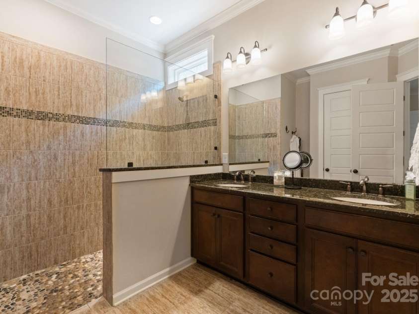 5137 Rialto Street, Belmont, NC 28012.  MLS# CAR4277416, YatesRealty ID 25831. The primary ensuite bathroom is a luxurious spa-inspired retreat, thoughtfully designed for comfort and rejuvenation. Featuring a spacious frameless glass shower, it offers a sleek and serene ambiance where modern sophist