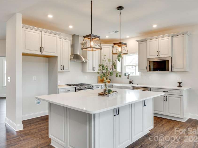 18011 Wilbanks Drive, Charlotte, NC 28278.  MLS# CAR4256574, YatesRealty ID 25857. A chef’s dream kitchen with a massive quartz island, designer lighting, and custom cabinetry that blends beauty and function.