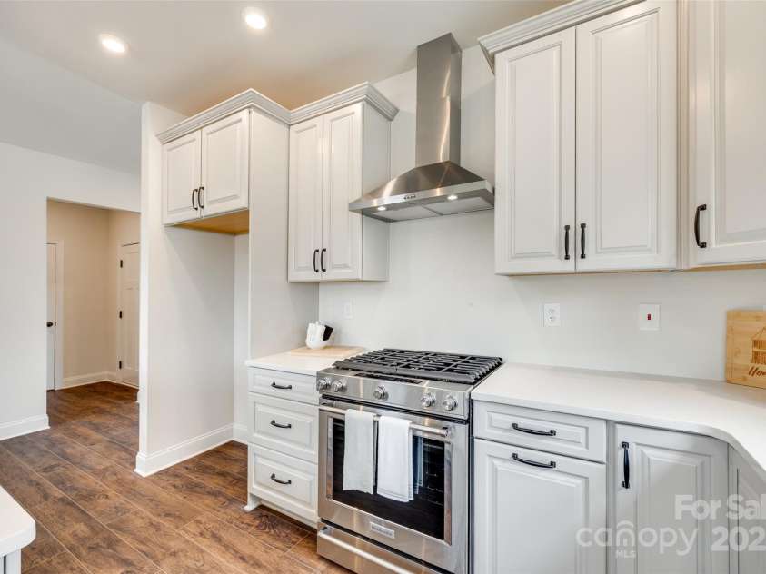 18011 Wilbanks Drive, Charlotte, NC 28278.  MLS# CAR4256574, YatesRealty ID 25857. Gourmet details shine in this stunning kitchen featuring a gas range, sleek vent hood, and stylish floor-to-ceiling cabinetry.