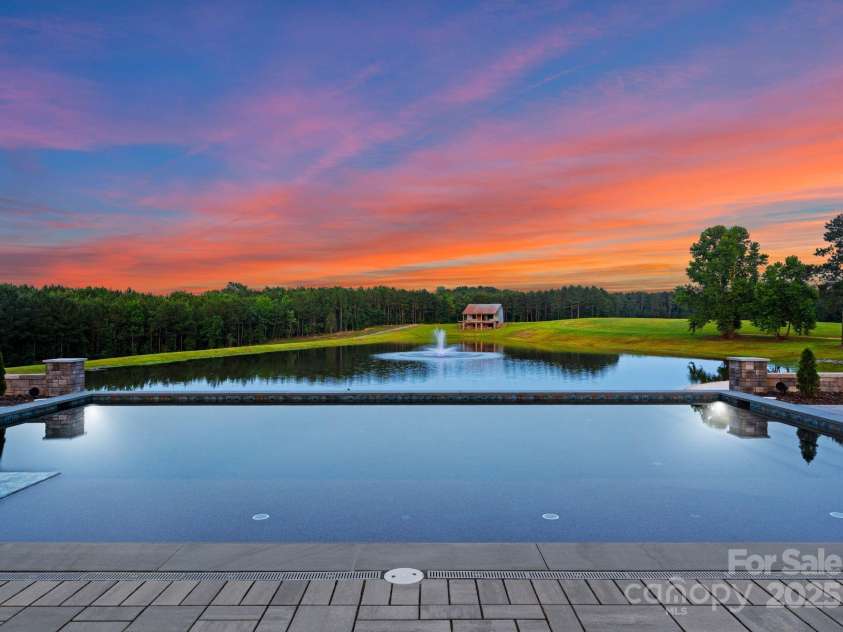 3759 NC 24/27 Highway, Cameron, NC 28326.  MLS# CAR4277323, YatesRealty ID 25897. Twilight Hunting Lodge Rear View Of Pool & Pond