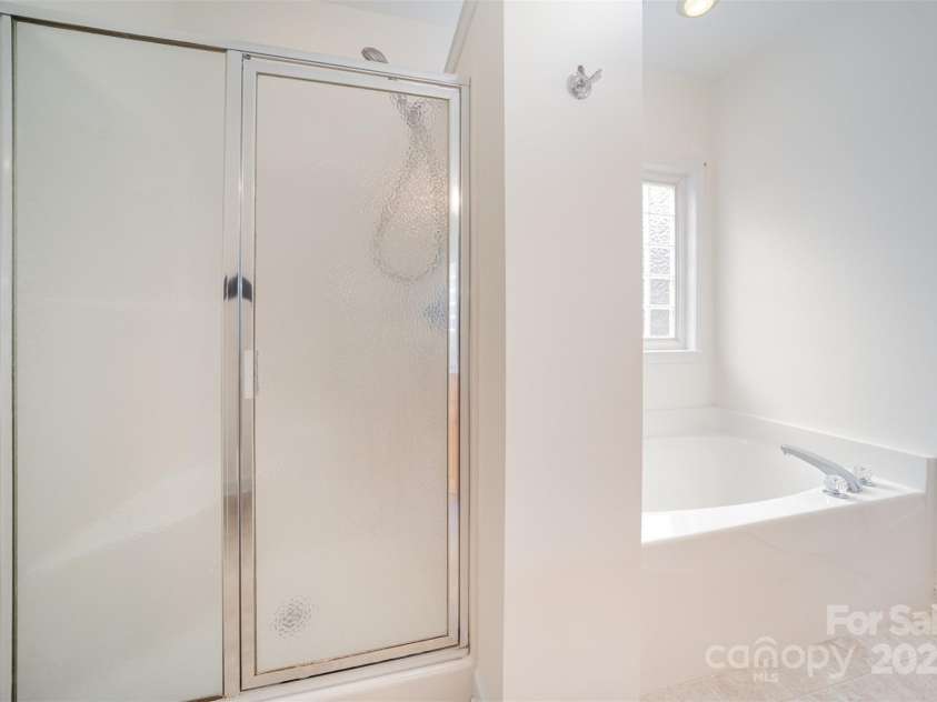 2909 Arbor Knoll, Concord, NC 28025.  MLS# CAR4273623, YatesRealty ID 25916. Step in shower in primary suite along with soaking tub.