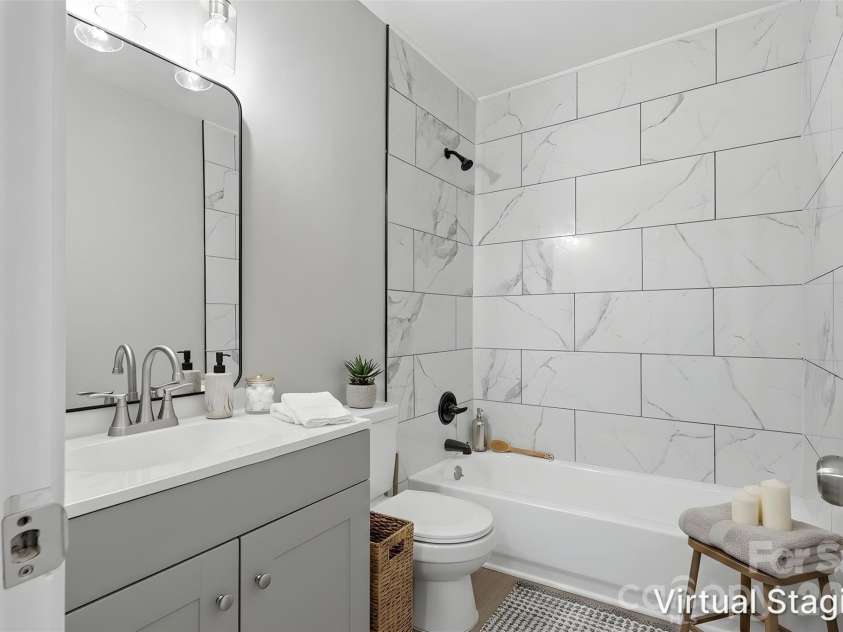 364 Leafmore Drive, Charlotte, NC 28213.  MLS# CAR4384246, YatesRealty ID 25936. Walking into the full bathroom, which is central to the home. Highlights include updated vanity (new cabinetry, sink, mirror & light fixture) & tile wall surround for tub/shower combo (virtually staged & enhanced).
