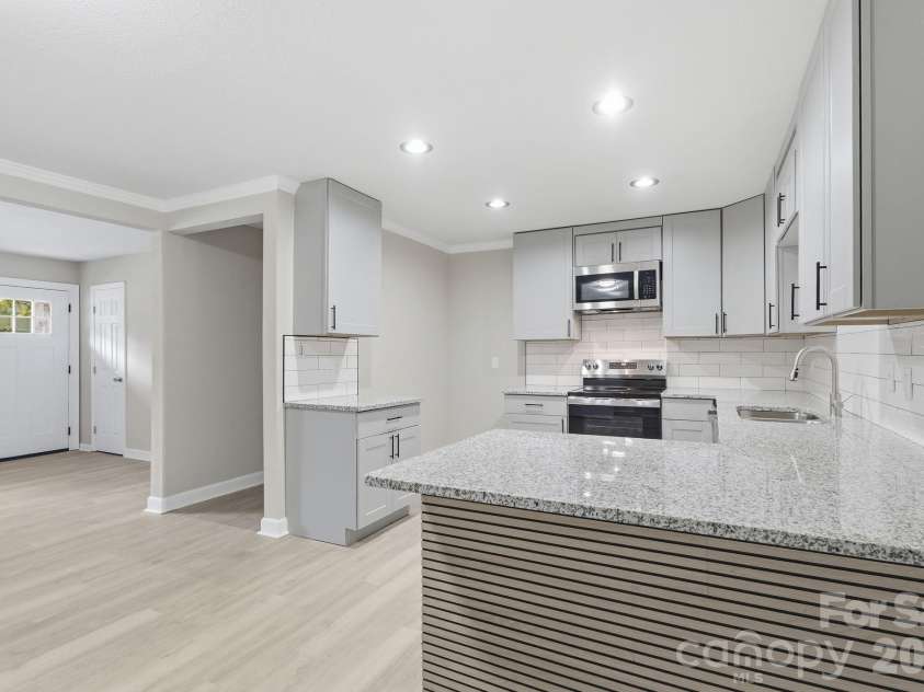 810 Echo Glen Road, Charlotte, NC 28213.  MLS# CAR4386453, YatesRealty ID 25944. Second shot of the updated kitchen, emphasizing how it flows into the primary living space. Open entry in center is hallway leading to second, third & fourth bedrooms.