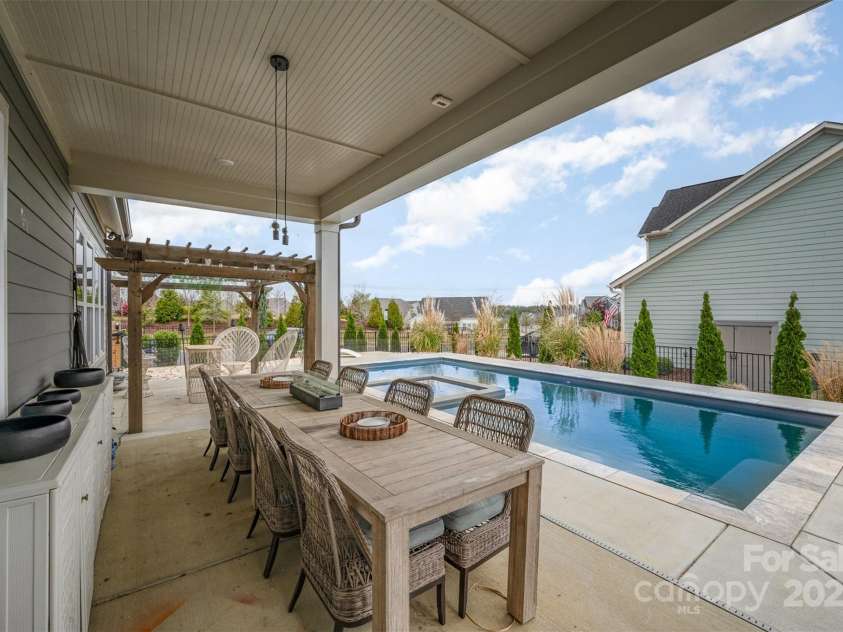 2332 Paddlers Cove Drive, Clover, SC 29710.  MLS# CAR4242429, YatesRealty ID 25958. Second covered patio with ceiling fan prewire.  Used as outside dining with two dining tables and great view of pool.