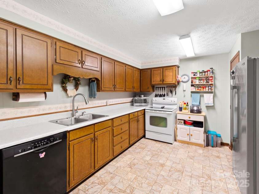 1400 Watershed Road, Mars Hill, NC 28754.  MLS# CAR4280588, YatesRealty ID 26016. You’ll enter this very meticulously kept kitchen with plenty of cabinets from the dining room. Pantry to the right on other side of refrigerator.