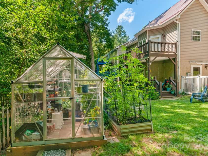 28 Grove Garden Avenue, Candler, NC 28715.  MLS# CAR4278254, YatesRealty ID 26090. Back yard with green house