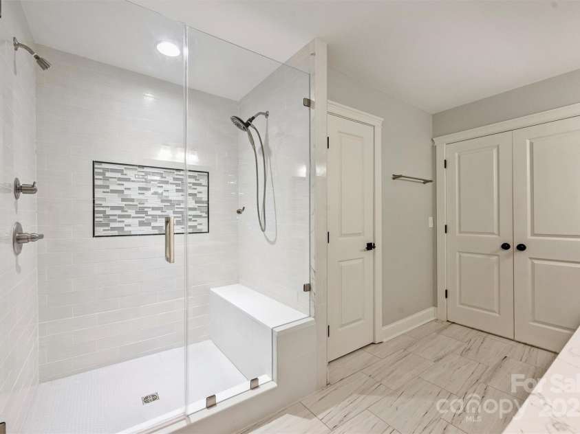 1522 Barberry Court, Charlotte, NC 28211.  MLS# CAR4258498, YatesRealty ID 2611. Huge, seamless, glass-enclosed, walk-in shower with dual heads and shower bench.