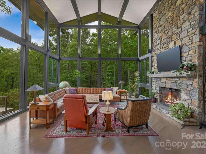 400 Kings Drive, Lake Lure, NC 28746.  MLS# CAR4264882, YatesRealty ID 2612. 2 stories of wall to ceiling windows and a natural stone fireplace to take in the chilly winter days.