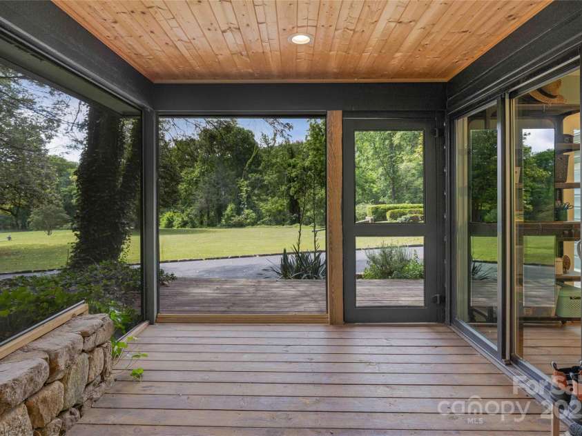 400 Kings Drive, Lake Lure, NC 28746.  MLS# CAR4264882, YatesRealty ID 2612. Beautiful exterior screened resting area off of the side cottage with natural stone. 