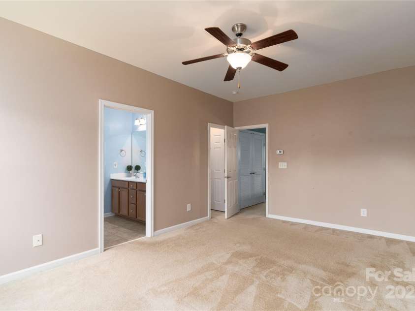1027 Writers Way, Cornelius, NC 28031.  MLS# CAR4275170, YatesRealty ID 26124. Ceiling fan and large walk-in closet in Primary Bedroom.