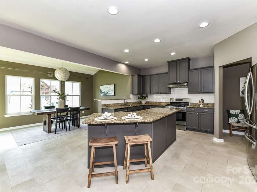 3533 Catherine Creek Place, Davidson, NC 28036.  MLS# CAR4279633, YatesRealty ID 26125. Spacious Kitchen features granite counters, stainless steel appliances including refrigerator to remain, island with seating/storage, tile back splash, pantry & dining area!