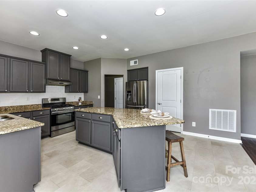 3533 Catherine Creek Place, Davidson, NC 28036.  MLS# CAR4279633, YatesRealty ID 26125. Spacious Kitchen features granite counters, stainless steel appliances including refrigerator to remain, island with seating/storage, tile back splash, pantry & dining area!