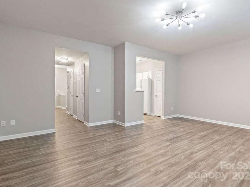 12207 Jessica Place, Charlotte, NC 28269.  MLS# CAR4235868, YatesRealty ID 26157. Living room looking into hall with half bath and laundry
