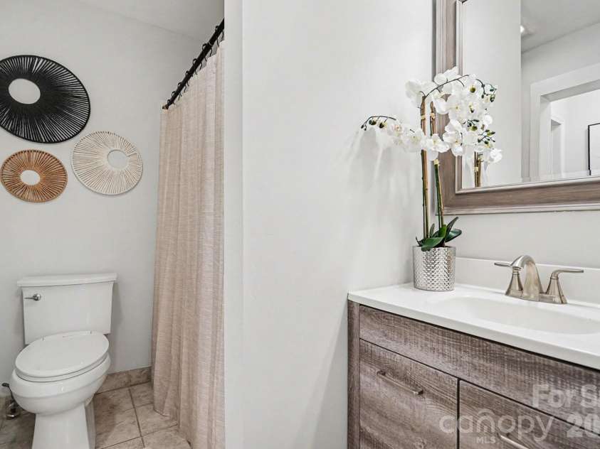 28 2nd Street, Cramerton, NC 28032.  MLS# CAR4357409, YatesRealty ID 26217. Well appointed bathroom with dual access- new vanity, mirror and lighting.