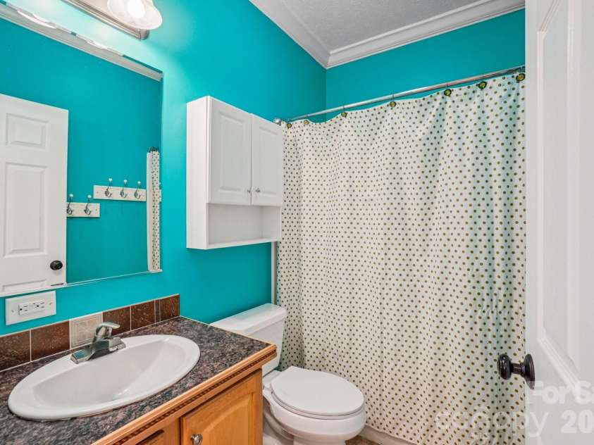 76 Cheraw Lane, Flat Rock, NC 28731.  MLS# CAR4345207, YatesRealty ID 2624. Convenient full bathroom on the main level — ideal for guests and everyday functionality.