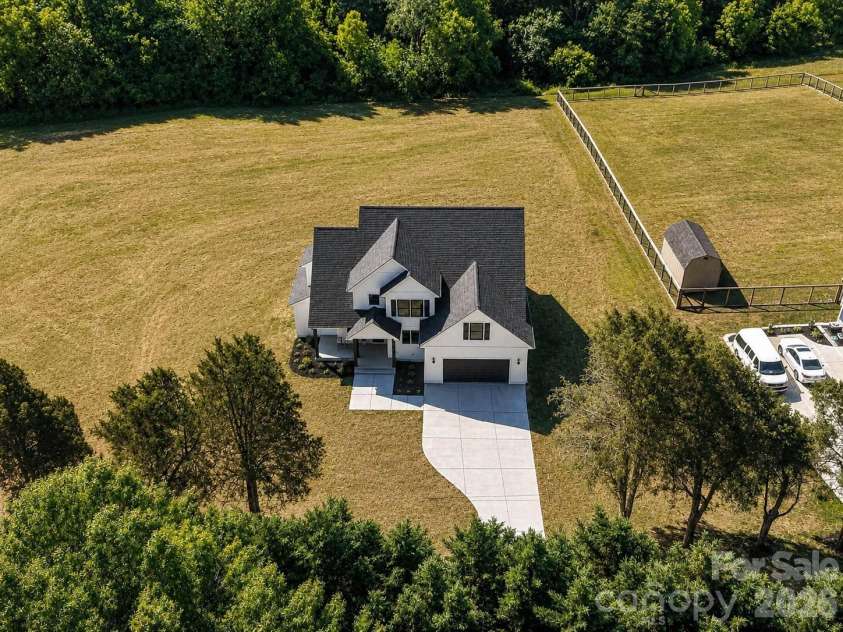 163 Lone Pine Road, Statesville, NC 28625.  MLS# CAR4383652, YatesRealty ID 26311. Aerial drone view highlights the home’s expansive lot, private tree-lined backdrop, and peaceful setting with plenty of outdoor space to enjoy. (Concept grass)