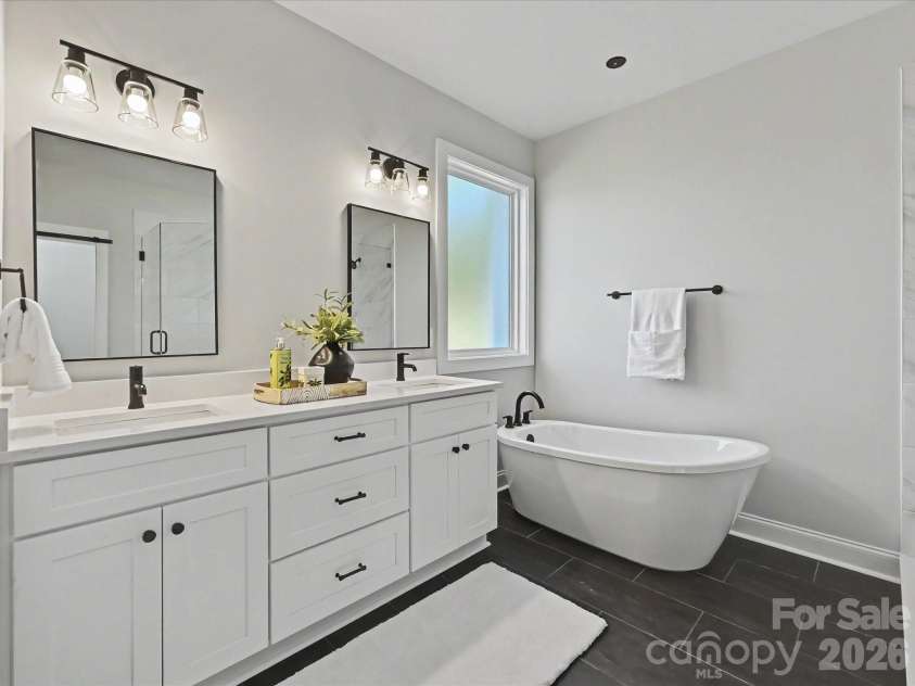 163 Lone Pine Road, Statesville, NC 28625.  MLS# CAR4383652, YatesRealty ID 26311. Luxurious primary bath features dual vanities, a freestanding soaking tub, and an oversized tiled walk-in shower with sleek modern finishes.