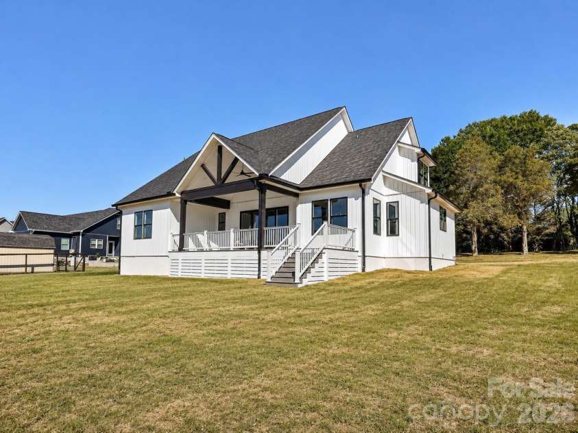 163 Lone Pine Road, Statesville, NC 28625.  MLS# CAR4383652, YatesRealty ID 26311. Rear elevation showcases charming modern farmhouse architecture, a covered back deck, and a spacious backyard backing to mature trees for added privacy. (Concept grass)