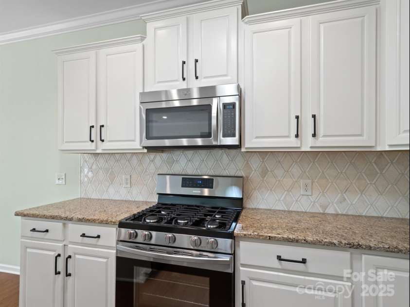 2035 Kennedy Drive, Indian Land, SC 29707.  MLS# CAR4278043, YatesRealty ID 26330. Kitchen with white cabinets and updated backsplash